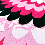 Close-up of fabric cape with patterned pink, white and black layers of fabric