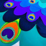 Close-up showing fabric cape layers with glittery eye-like felt ornaments