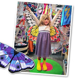 Photo of young girl spreading out butterfly wings with arms outstretched