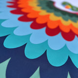 Close-up of cape layers of green, navy, blue, red, orange, and yellow fabric