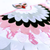 Close-up cape layers of patterned pink, white, grey, and black fabric