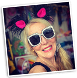 Beautiful lady radiating joy, smiling, and posing with stylish rhinestone glasses and furry black ear clips, adding a touch of playful sophistication to her ensemble.