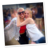 Stylish silver sequin fringe jacket worn at a music festival, the wearer posing with a friend. Radiating glamour and festival chic for an unforgettable look.