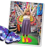 Photo of young girl spreading out butterfly wings with arms outstretched