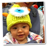 Charming green baby monster hat being worn by an adorable baby - a delightful and whimsical accessory for a touch of playful style.
