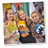 Three joyful friends posing with vibrant folded dinosaur towels.